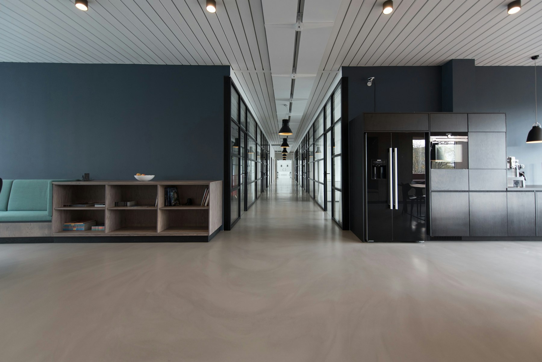 An open commercial interior with a dark feature wall, built-in storage and a polished floor.