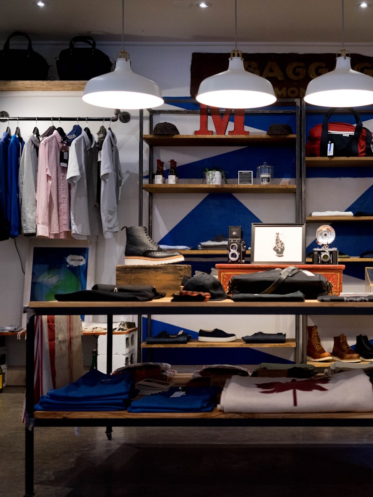 A retail showroom with open rails, timber shelving and displayed stock.