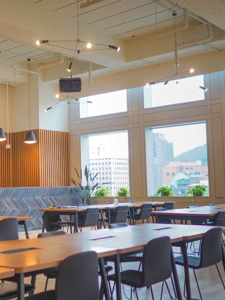 A bright open office with timber panelling, meeting tables and a city view.