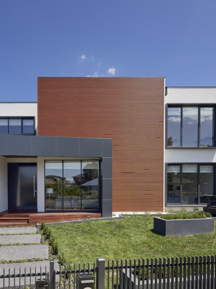 A contemporary two-storey house in brick and render, seen from the street.