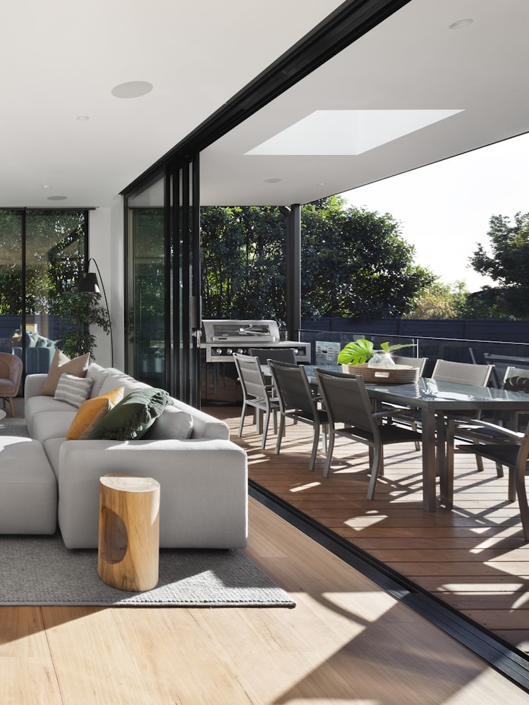 A living room opening through full-height glazing onto a covered outdoor terrace.